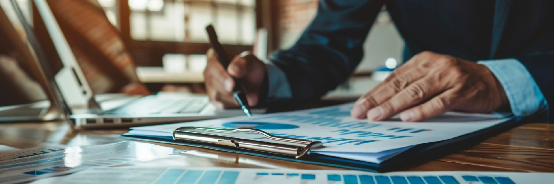 Homme en costume analysant des graphiques et donnÃ©es financiÃ¨res au stylo