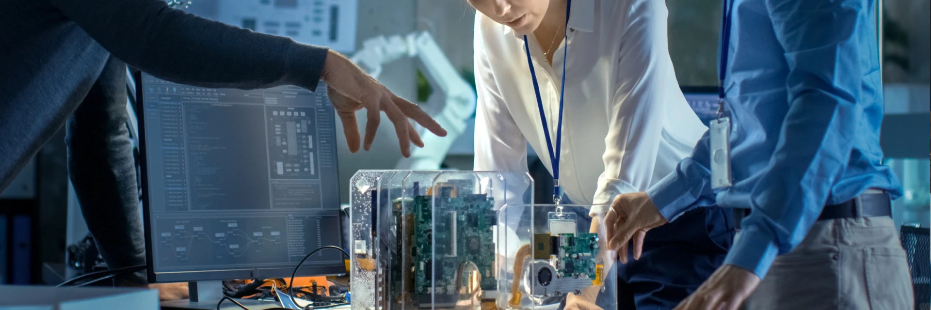 Ã‰quipe d'ingÃ©nieurs analysant un prototype Ã©lectronique complexe dans un laboratoire moderne